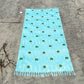 Coastal beach blanket with tassel edges and soft coastal print—your go-to for beach lounging and summer travel.